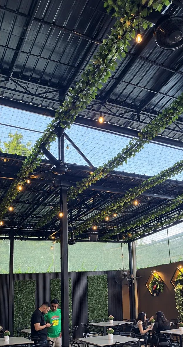 Terraza de Caldos Constitución con plantas y luces colgantes